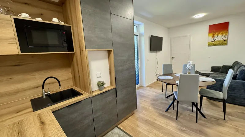 Wohnraum des Apartments mit französischen Fenstern und Zugang zum Balkon