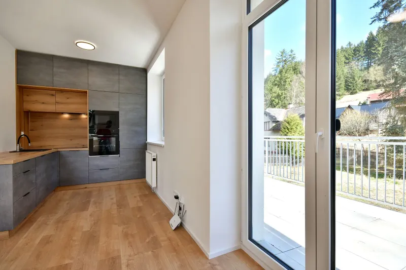 Obytný prostor apartmánu s francouzskými okny a výstupem na balkon